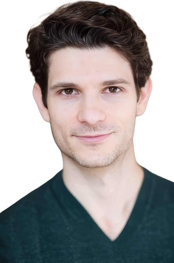 A young man with curly hair and a slight smile, wearing a dark v-neck shirt against a white background.